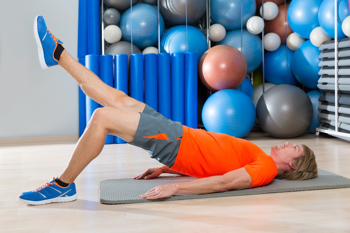 Man at the gym doing a hip stability exercise